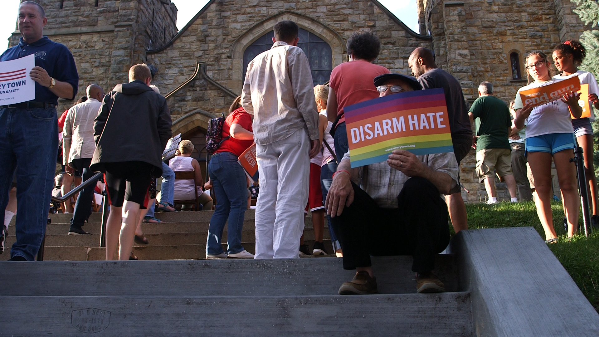 Man holding a "Disarm Hate" sign at Pittsburgh rally.
